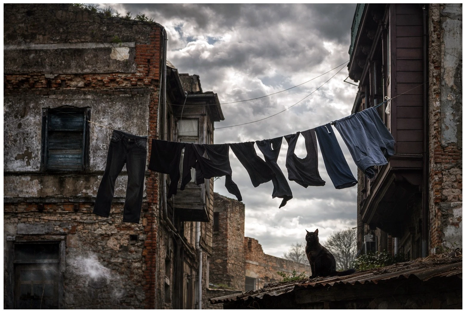 Laundry on a line between old buildings beneath cloudy skies