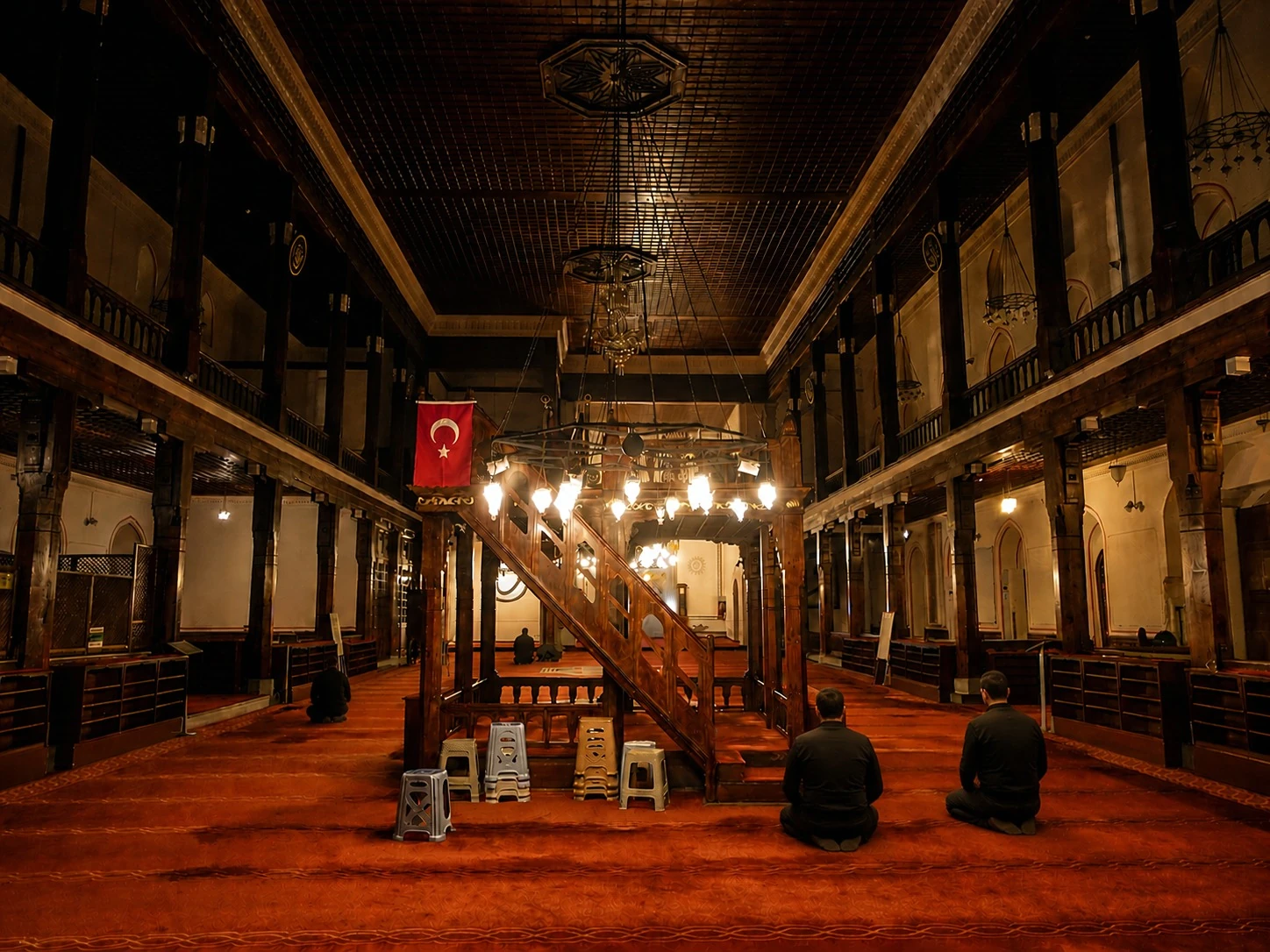 People kneeling in a warmly lit mosque interior