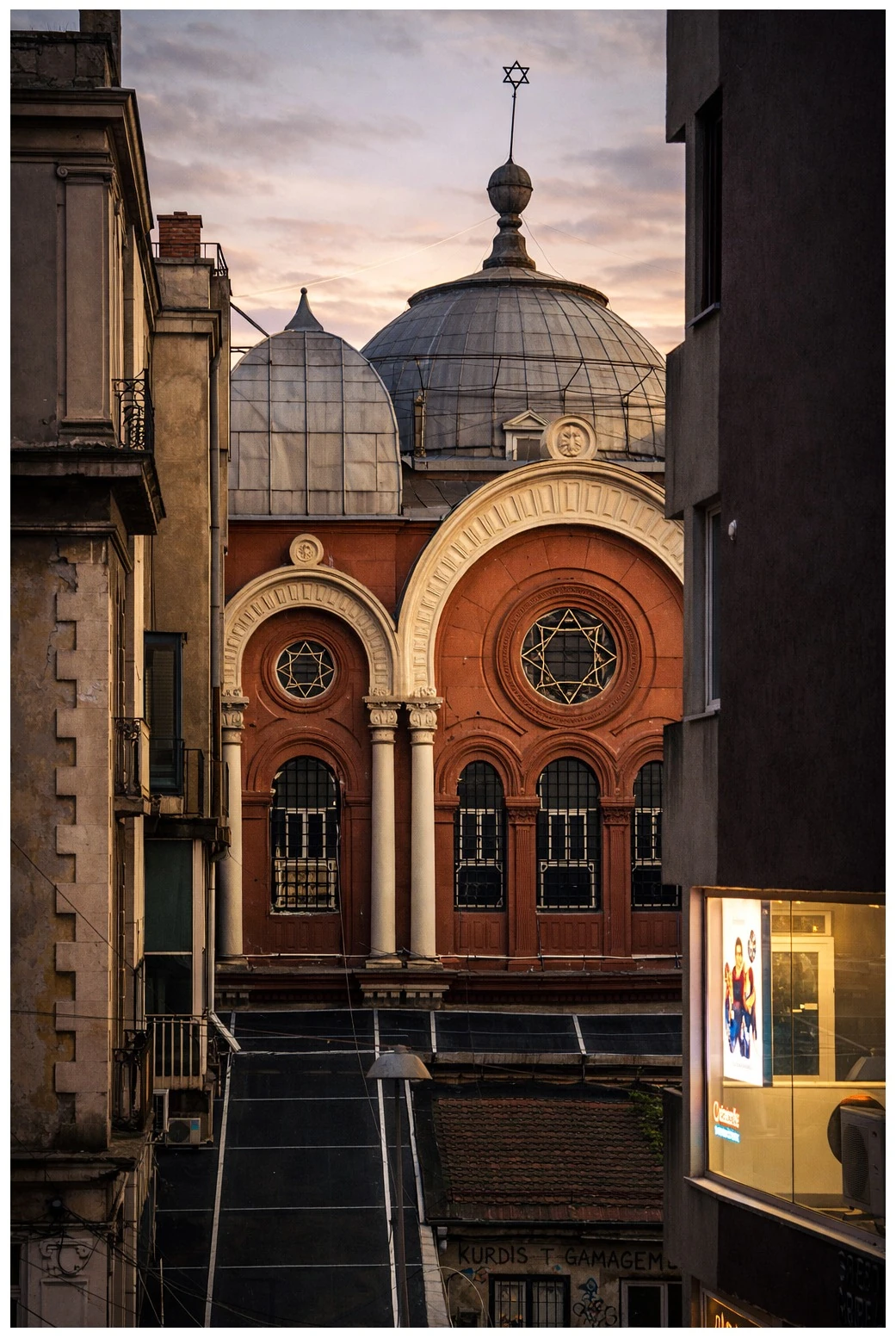 An ornate synagogue facade framed by neighbouring buildings