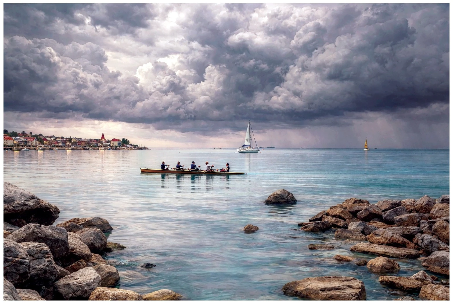 A team paddling a long boat across calm water