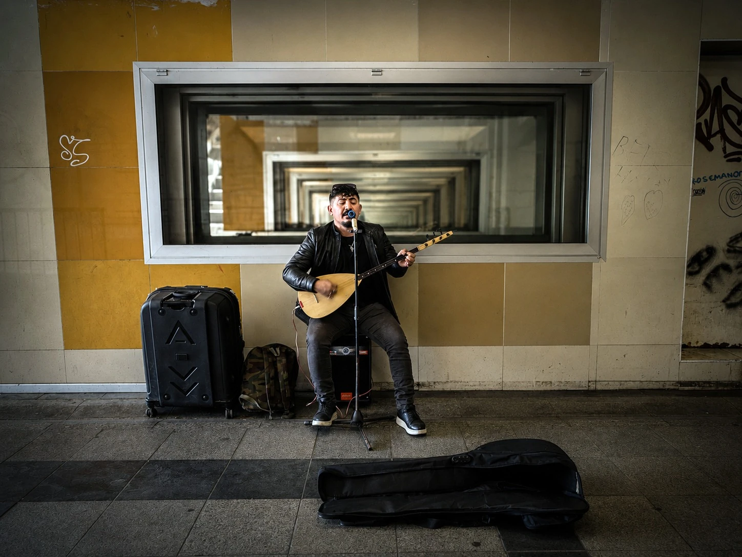 A musician playing a stringed instrument in an underground passage
