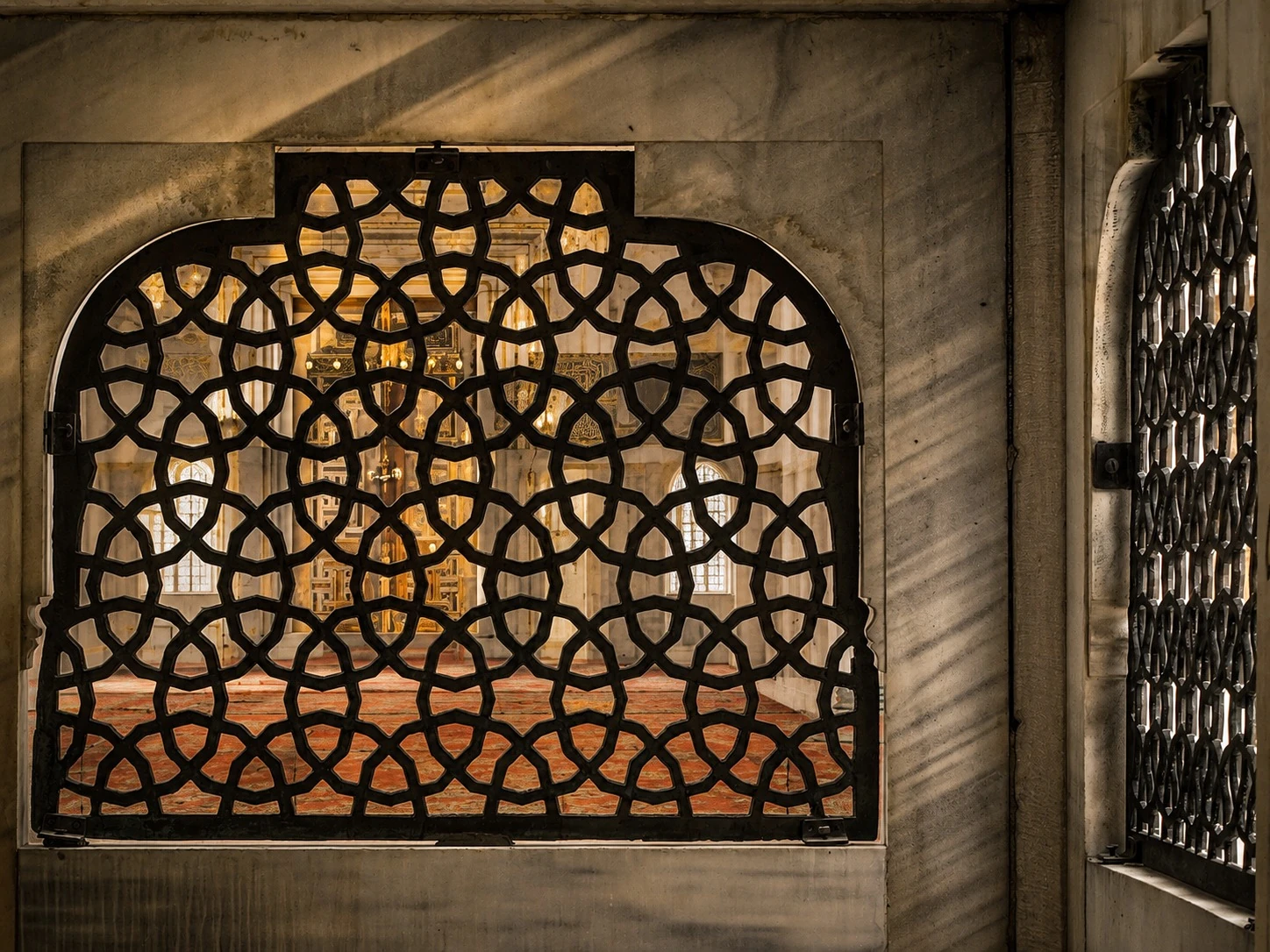 An ornamental metal grille with warm light passing through it
