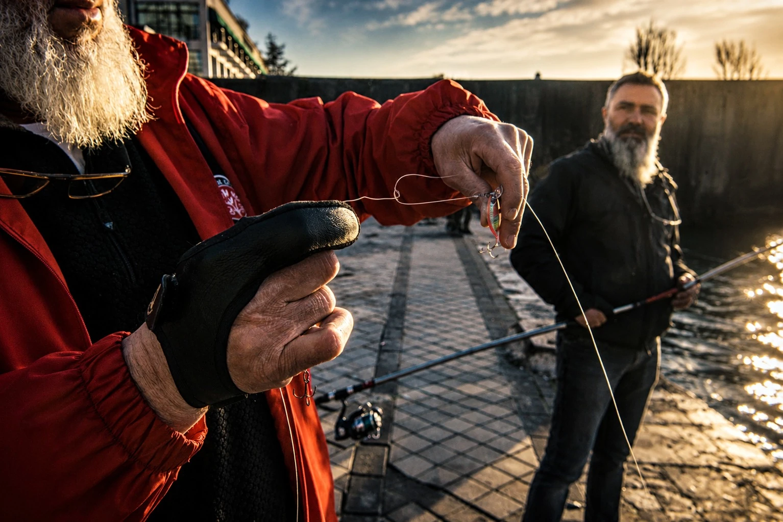 A fisherman preparing bait and line beside the water