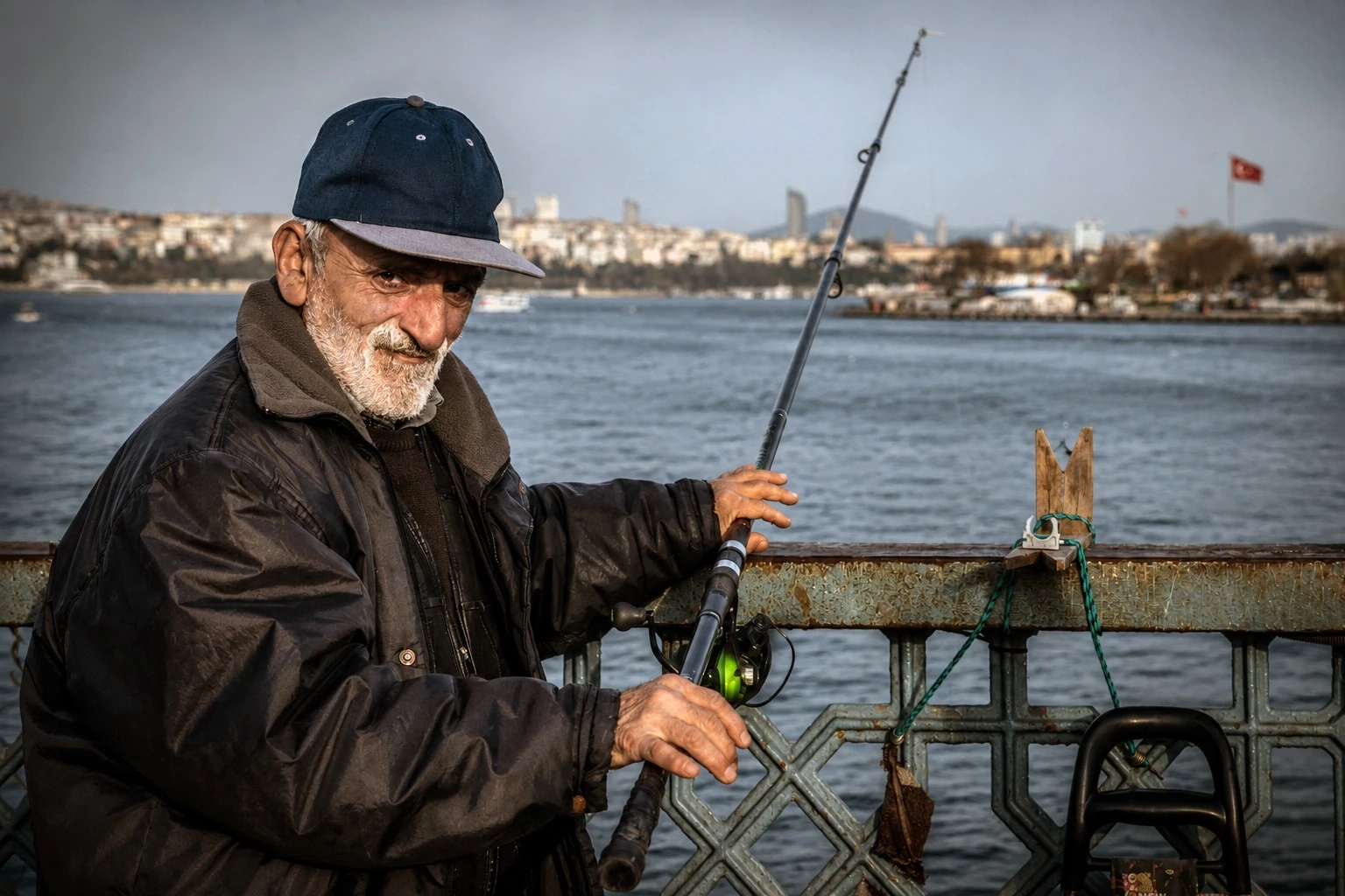 A man holding a fishing rod beside the waterfront