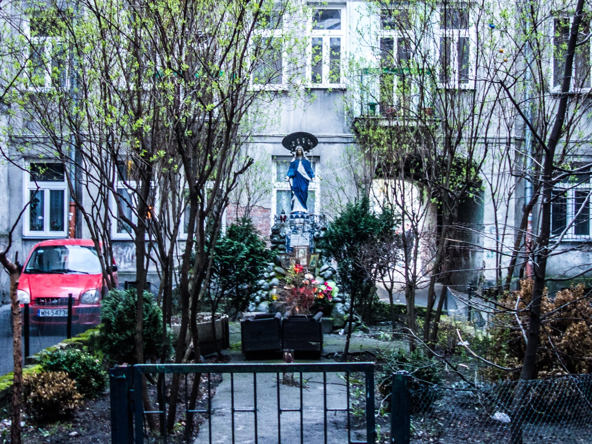 A Marian shrine among trees in a residential courtyard