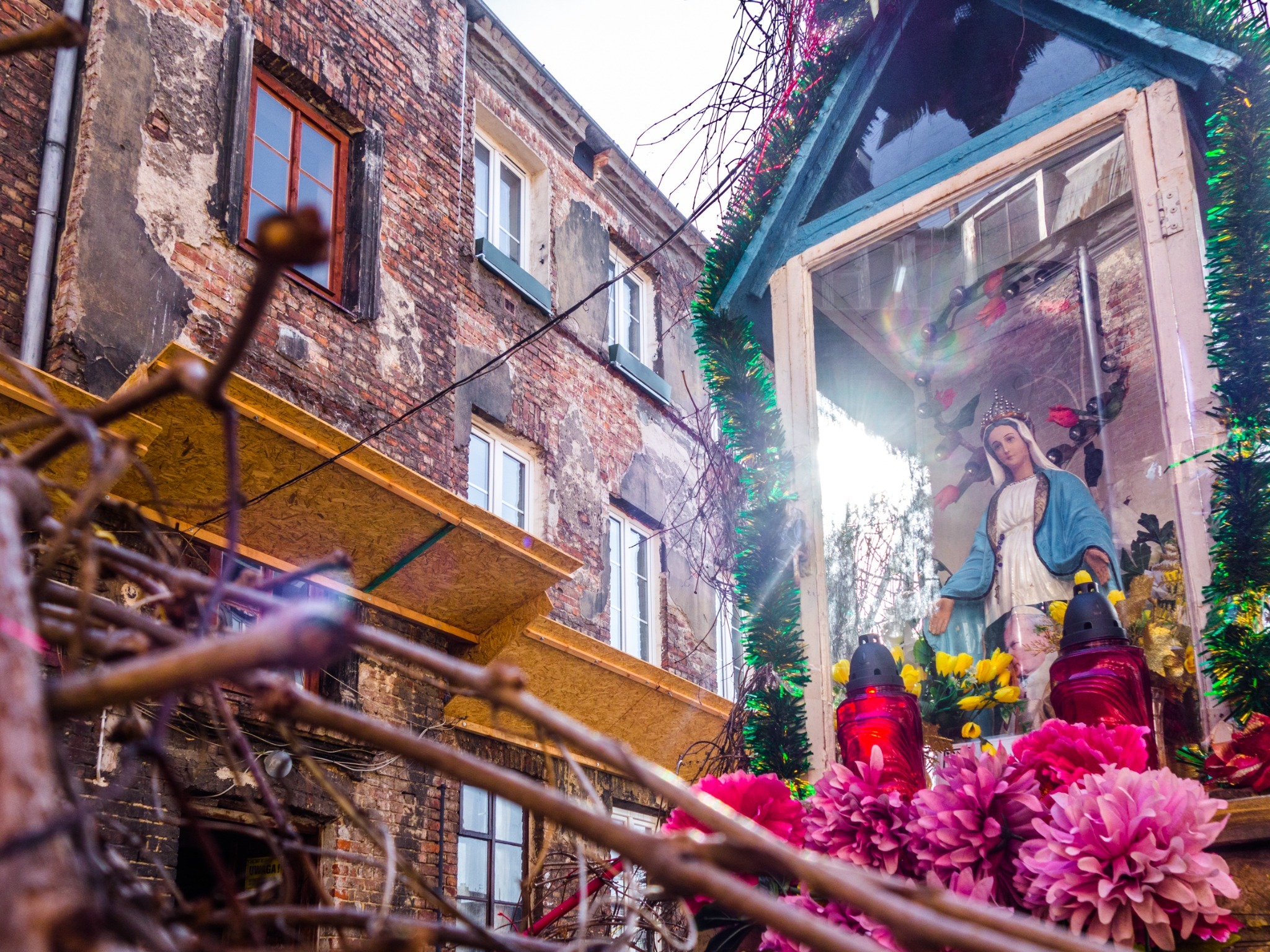 A flower-covered shrine surrounded by old courtyard walls