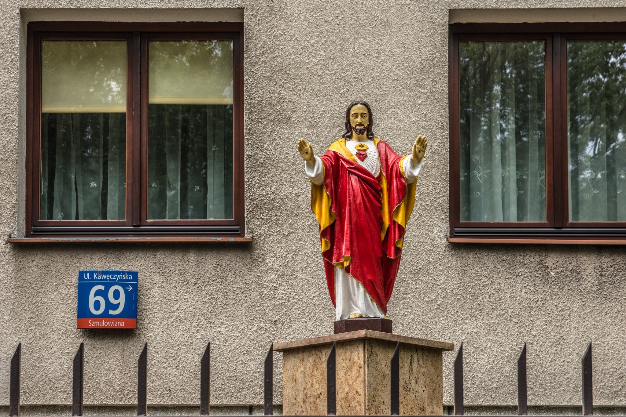 A statue of Jesus in a red robe between two windows